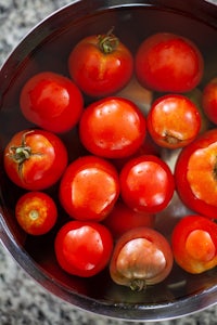 a bowl of tomatoes in a bowl of water